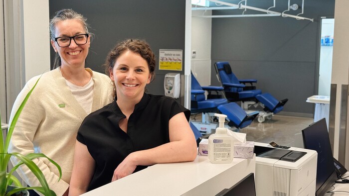 Deux femmes posent pour la caméra.