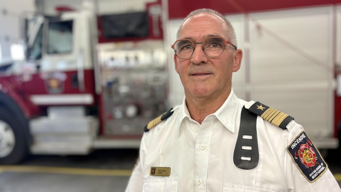 Yves Landry devant un camion de pompiers.