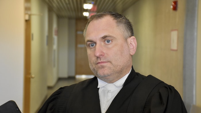 Un homme vêtu d'une toge d'avocat.