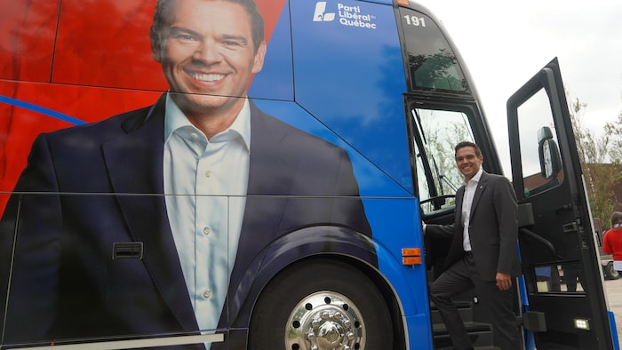 Charles Milliard montant dans son autobus de campagne.