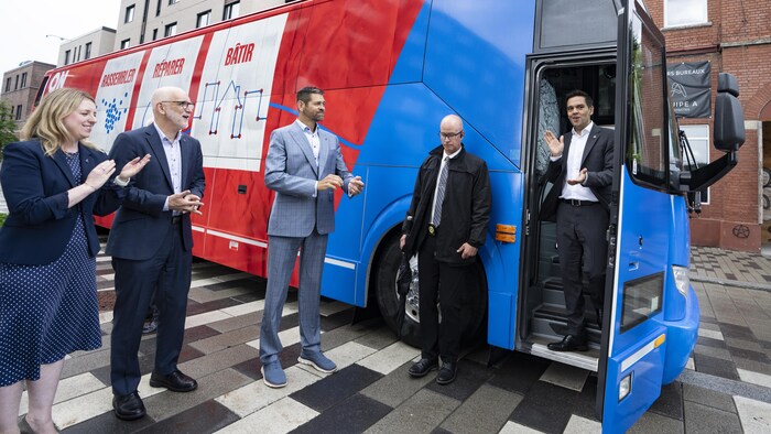 Charles Milliard descend d'un autobus de campagne du Parti libéral du Québec sous des applaudissements.