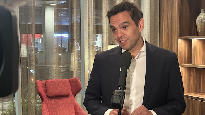 Charles Milliard debout dans un salon. 