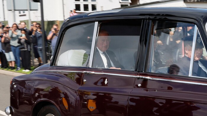 Un automóvil que transportaba al rey Carlos y la reina Camila sale de una base de la Royal Air Force cerca de Londres. 