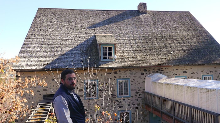Le chargé de projet montre la toiture du moulin.