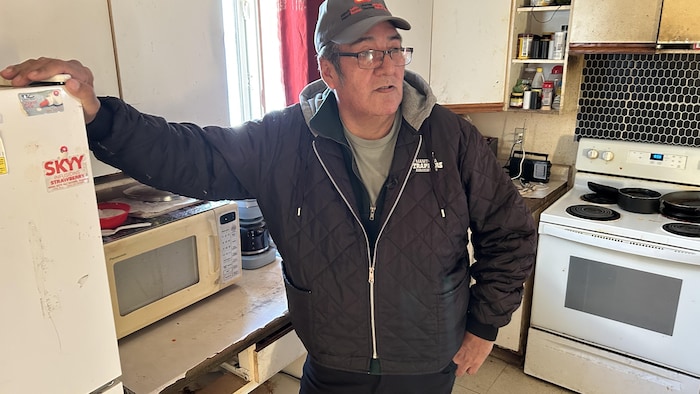 Portrait de Randy Spence debout à côté d'électroménagers dans un local. 