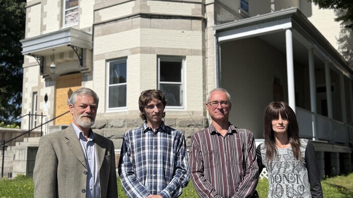 Trois hommes et une femme devant le Château Beauce à Sainte-Marie.