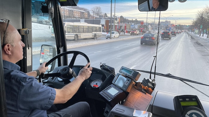 Un homme au volant d'un autobus.