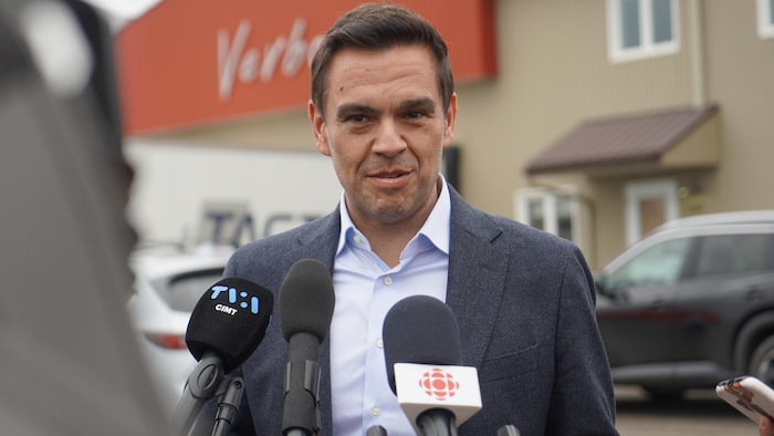Charles Milliard s'adresse aux médias devant une usine.