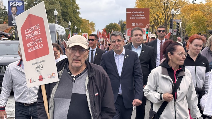 Eric Duhaime entouré de gens dans la rue.