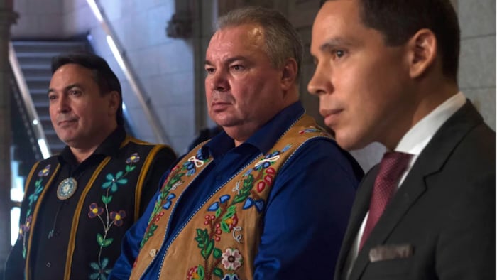 De gauche à droite, le chef national de l'Assemblée des Premières Nations Perry Bellegarde, le président de la Manitoba Metis Federation David Chartrand et le président de l'Inuit Tapiriit Kanatami Natan Obed écoutent la question d'un journaliste sur la Colline du Parlement en 2016.