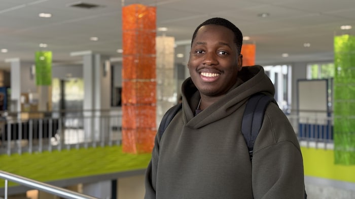 Un étudiant sourit à l'objectif dans un corridor du Cégep de Matane.