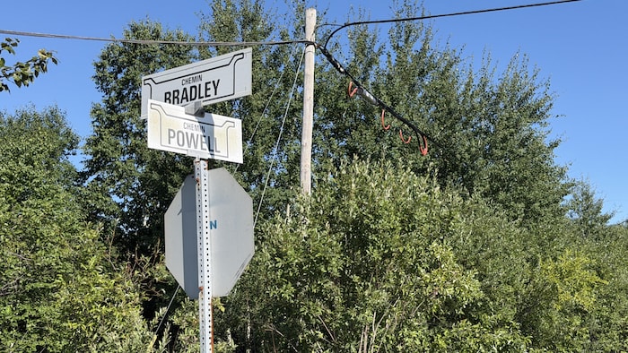 Une pancarte d'arrêt au dessus de laquelle on peut lire l'inscription des chemins Bradley et Powell.
