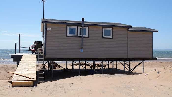 Un chalet sur des pieux droits muni d'une passerelle.