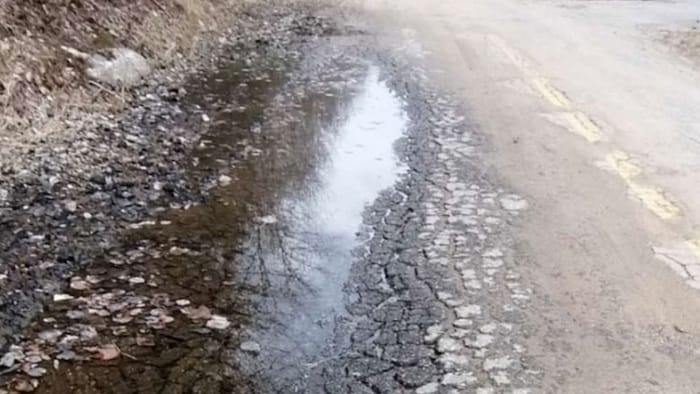 Un chemin d'asphalte en mauvais état.
