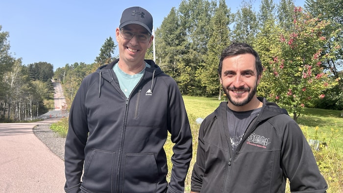Deux hommes sourient devant l'objectif.