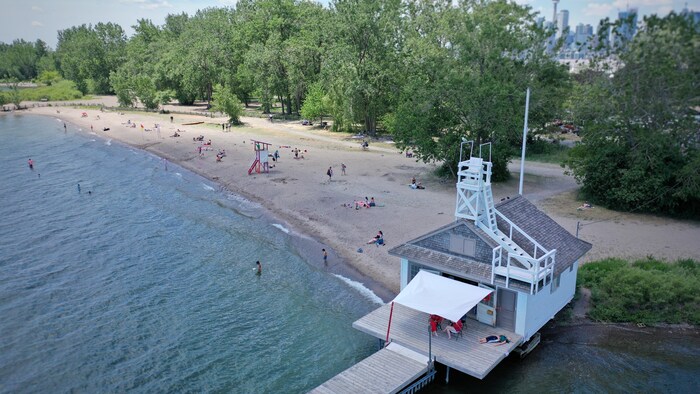 Photos de la plage Cherry prises par un drone sur laquelle on voit le poste de secours et son embarcadère, les maîtres-nageurs et les baigneurs sur le sable.