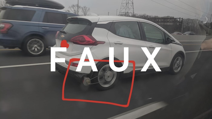 Une Chevrolet Bolt munie d'un générateur attaché à sa roue. Le mot FAUX est superposé à l'image.