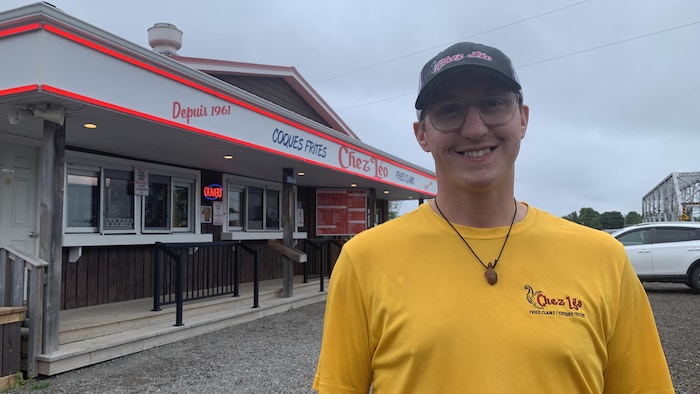 A man wearing a yellow t-shirt placed in front of a snack. not so easy find student new