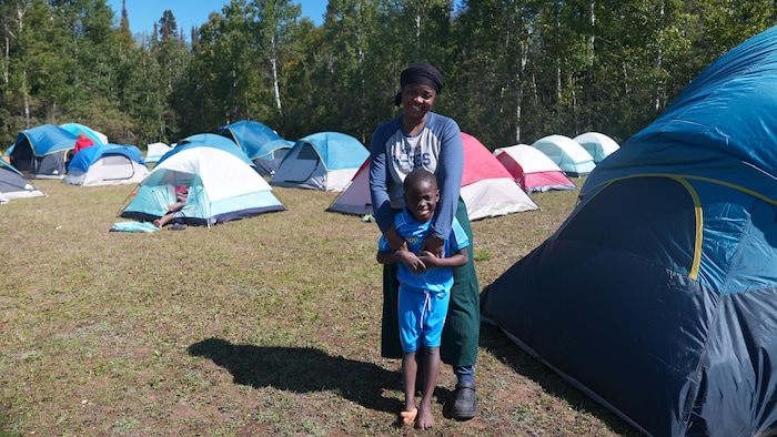 Une femme et son fils font du camping.