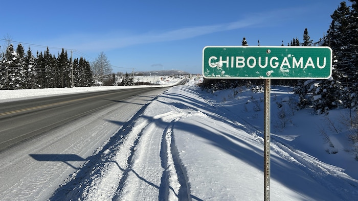 Une affiche mentionnant le nom de Chibougamau en bordure d'une route.