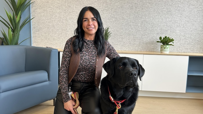 Une femme prend la pose avec un chien. 