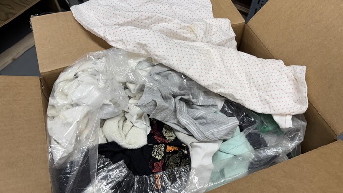 Gros plan sur une boîte ouverte, pleine de chiffons en coton.