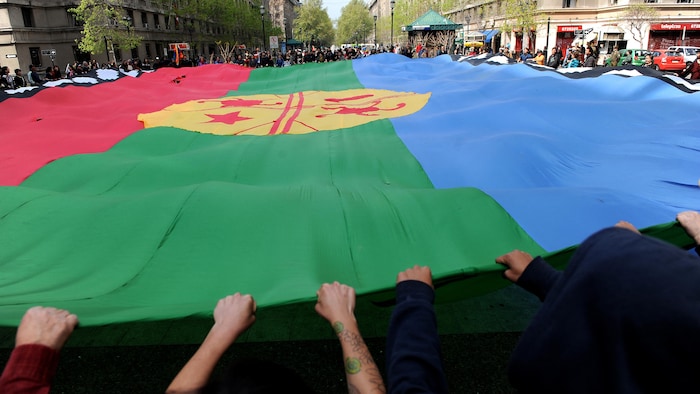 Photo d'archives - Des familles des 35 militants autochtones mapuches en grève de la faim portent un drapeau mapuche lors d'une manifestation devant le palais présidentiel de La Moneda, à Santiago, le 30 septembre 2010. Les prisonniers indigènes mapuches demandent au gouvernement d'annuler les lois antiterroristes qui, selon eux, ont été appliquées injustement à leurs revendications de terres ancestrales. 