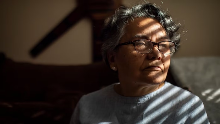 Gloria Diaz, sitting in her Vancouver home, reflects on the 50 years that have passed since the coup in Chile took place. (Ben Nelms/CBC)