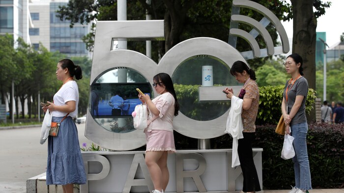 Des employés attendent l'arrivée d'un bus devant les bureaux de Huawei à Shenzhen, en Chine.