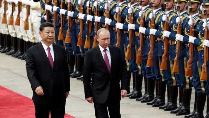 Le président russe (droite) Vladimir Poutine passe en revue l'armée chinoise en compagnie de son homologue Xi Jinping, à Beijing. 