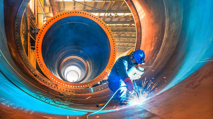 Un soudeur s'affaire à l'intérieur de la tour d'une éolienne dans une usine de Lianyungang, dans l'est de la Chine.