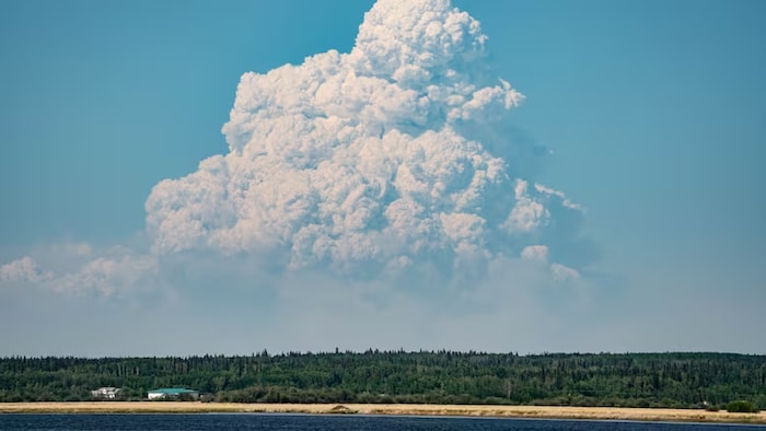 Une épaisse fumée de feu de forêt s'élève dans le ciel de Chipewyan Lake, dans le nord de l'Alberta, en juin 2025.