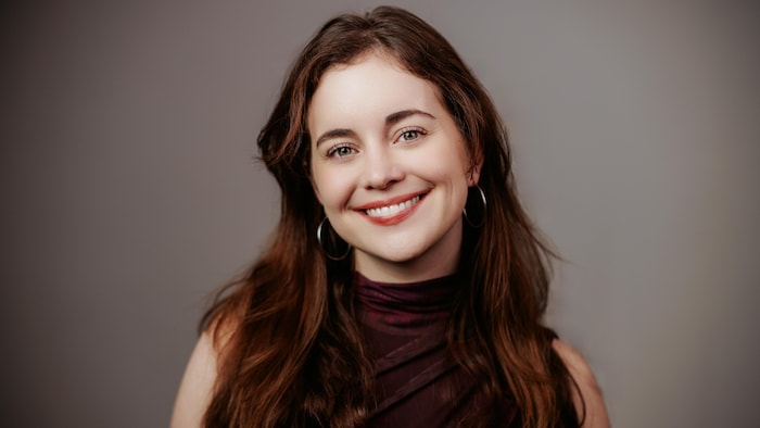 Chloé Dumoulin pose devant un fond gris.