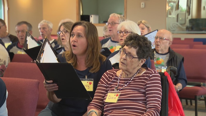 Marcy Casselman et sa mère Diane Mackenzie chantent entourées d'une dizaine de personnes