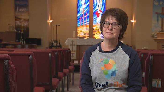 Une dame est assise au milieu d'une église.