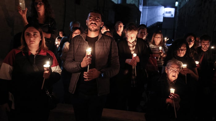 Des Palestiniens participent à une veillée aux chandelles devant l'église Saint-André à Ramallah, en Cisjordanie, en hommage aux victimes de la guerre à Gaza.