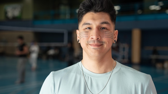 Portrait de Chris Angatookalook, qui porte un tatouage traditionnel au visage.