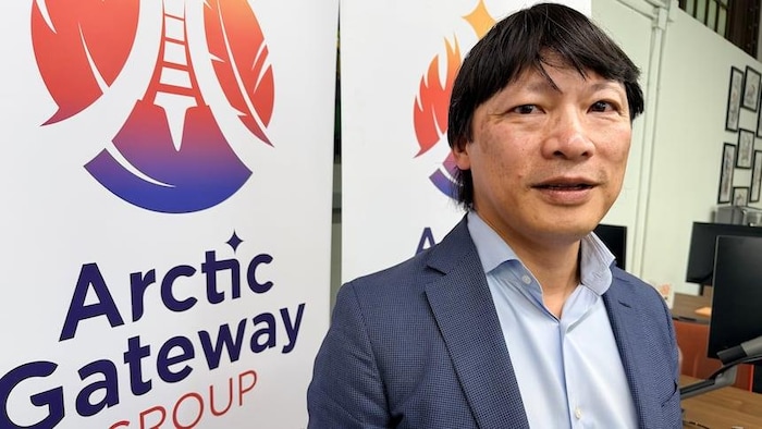 Chris Avery, devant des pancartes du Arctic Gateway Group.