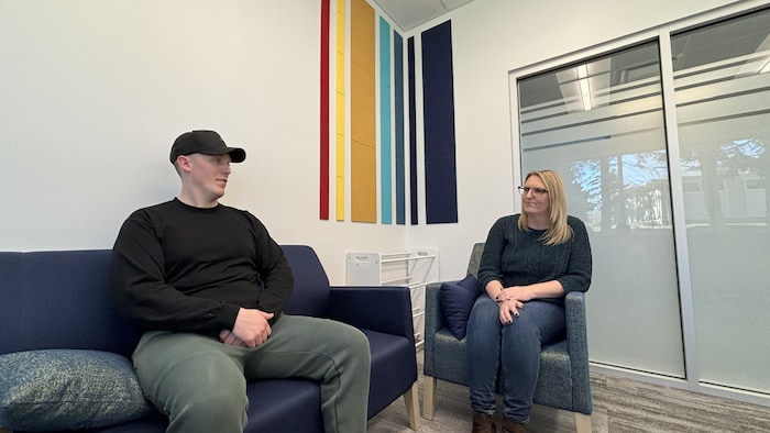 Chris et Lyndsay discutent assis dans un salon.