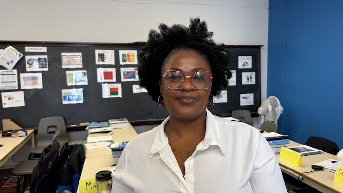 Une femme debout dans une salle pose pour la photo. 
