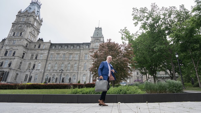 Christian Dubé quittant l'Assemblée nationale, valise en main.