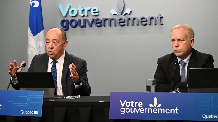 Christian Dubé et Luc Boileau sont assis durant une conférence de presse.