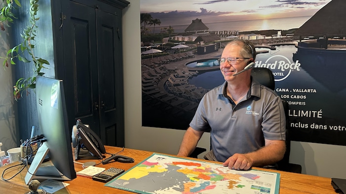 Christian Dubreuil, conseiller en voyages chez Aquaterra, regarde son ordinateur.