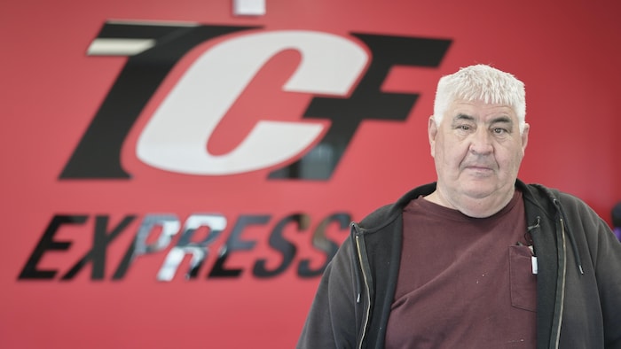 Christian Forcier devant l'enseigne de lad entreprise.