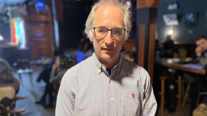 Christian Milot debout dans une salle pour se faire prendre en photo. 