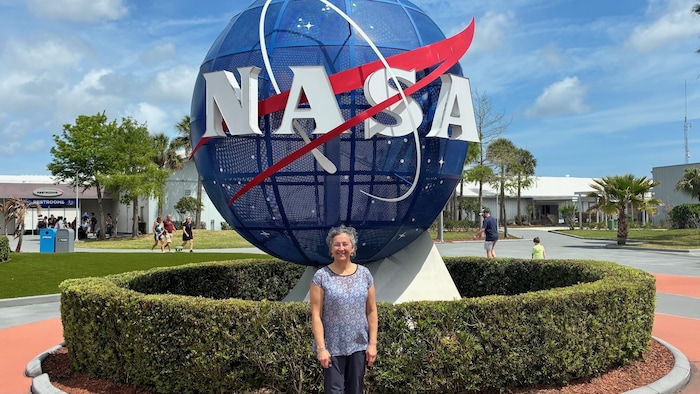 Christine Chénard devant le logo de la NASA.