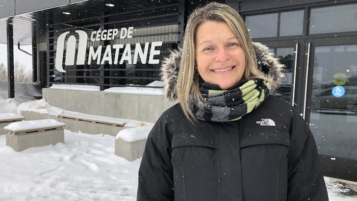 Christine Dugas sourit devant l'entrée du Cégep de Matane, en hiver.