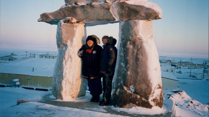 Christine Egan et Ellen Judd sous un inukshuk dans un paysage enneigé.