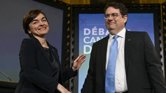 Christine Fréchette et Bernard Drainville, souriants, font un mouvement pour se serrer la main.