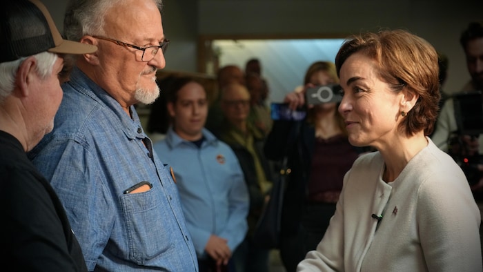 Christine Fréchette serre la main d'un homme.